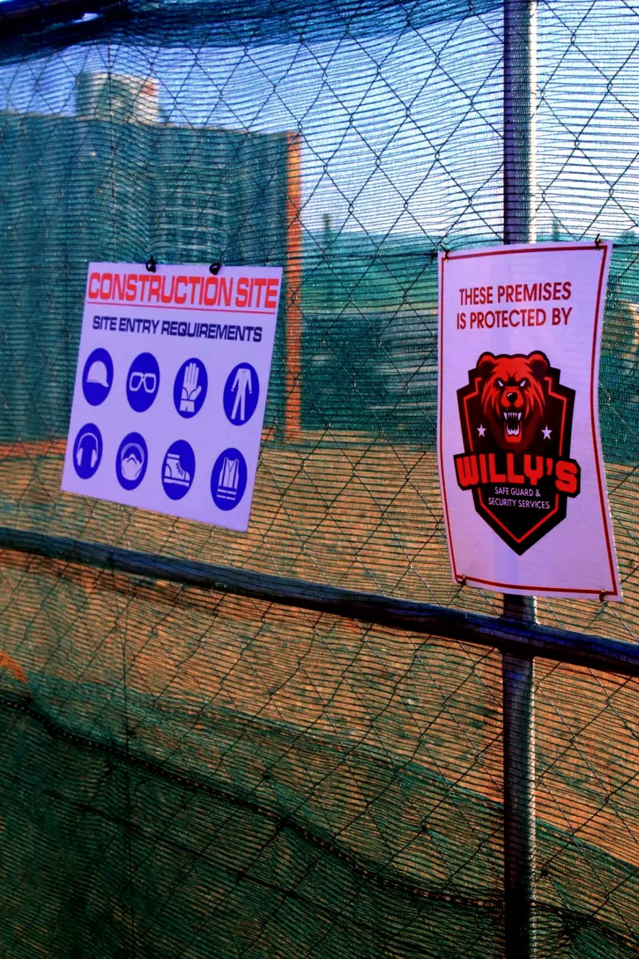 Board on a construction-site fence in Upington reading: these premises are protected by Willy's Security